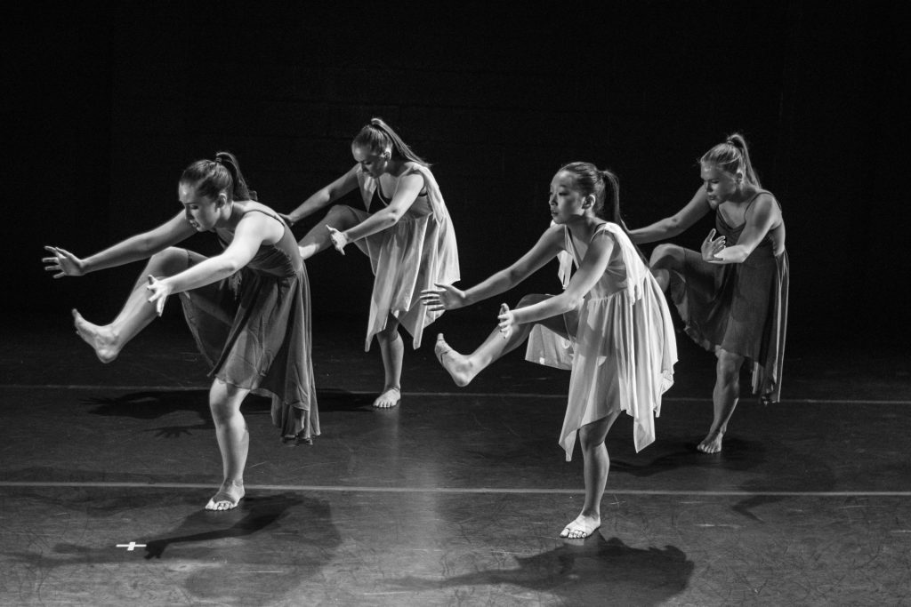 Fotografía en escala de grises de cuatro mujeres bailando